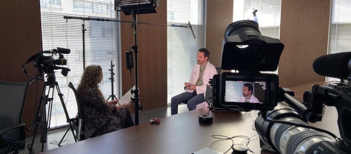 camera crew filming lit interview in office in Barcelona